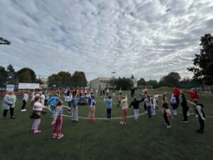 Uczniowie klas 1-3 podczas rozgrzewki przygotowującej do biegów "Pełni mocy"